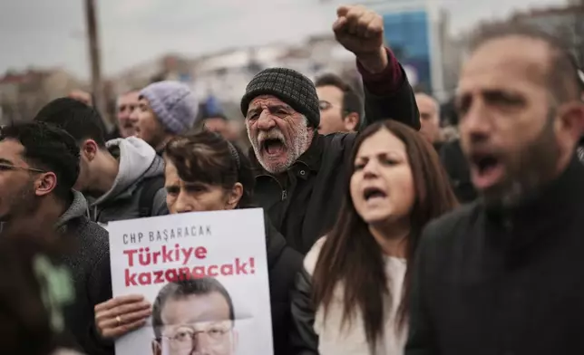 People chant slogans and hold posters of Istanbul Mayor Ekrem Imamoglu as they protest outside the Vatan Security Department, where Imamoglu is expected to be taken following his arrest in Istanbul, Turkey, Wednesday, March 19, 2025. (AP Photo/Francisco Seco)