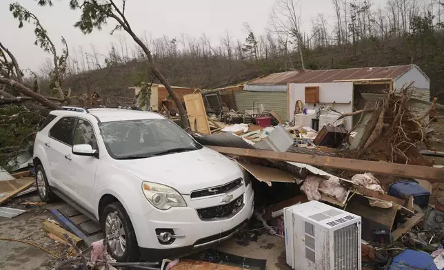 A vehicle sits in front of a damaged home and debris from a severe storm Saturday, March 15, 2025, in Wayne County, Mo. (AP Photo/Jeff Roberson)