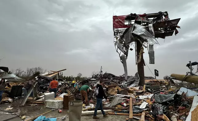 People work through the debris of the Cave City Auto Parts store on Saturday, March 15, 2025 after a severe weather storm Friday night in Cave City, Ark. (Staci Vandagriff/Arkansas Democrat-Gazette via AP)