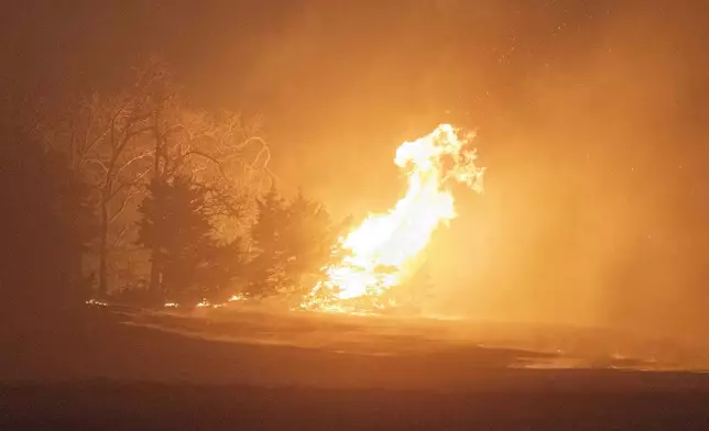 A wildfire burns at night on Friday, March 14, 2025, south of Langston, Okla. (AP Photo/Alonzo Adams)