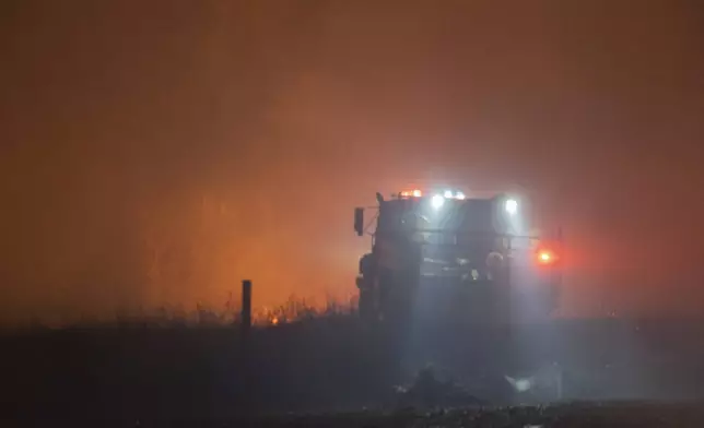 Fire crews battle a wildfire Friday, March 14, 2025, south of Langston, Okla. (AP Photo/Alonzo Adams)
