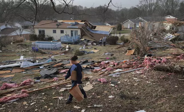 Missy, who declined to give her last name, searches for photographs in a debris field behind a relative's home after a severe storm in Bridgeton, Mo., Saturday, March 15, 2025. (Robert Cohen/St. Louis Post-Dispatch via AP)