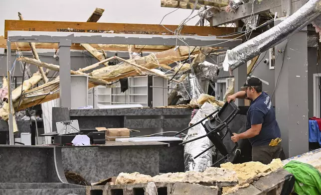 Dustin Halcom of the Cord Fire Department helps salvage what's left of the Walling Drug store Saturday, March 15, 2025 after it was destroyed by a severe storm that ripped through Cave City, Ark., late Friday night. (Staci Vandagriff/Arkansas Democrat-Gazette via AP)