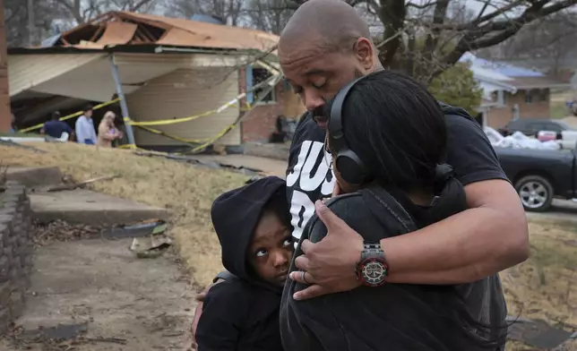 Marcus Cole embraces his daughters while standing in front of his destroyed home after a severe storm in Bridgeton, Mo., Saturday, March 15, 2025. (Robert Cohen/St. Louis Post-Dispatch via AP)