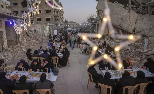 Widows and mothers of war victims gather for Iftar, the fast-breaking meal, organized by local NGOs in the devastated Jobar neighborhood of Damascus, Syria, Friday, March 14, 2025. (AP Photo/Ghaith Alsayed)