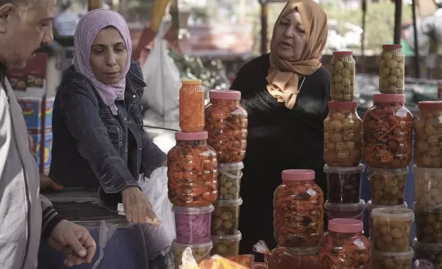 People buy pickles as they prepare for breakfast during the holy fasting month of Ramadan, in Cairo, Egypt, Friday, March 7, 2025. (AP Photo/Amr Nabil)