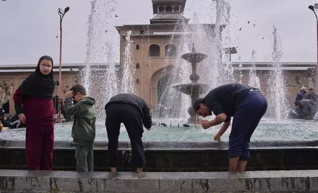 Kashmiri Muslims wash themselves at a fountain in the compound of Jamia Masjid or grand mosque during the first Friday of the fasting month of Ramadan in Srinagar, Indian controlled Kashmir, Friday, March 7, 2025. (AP Photo/Dar Yasin)