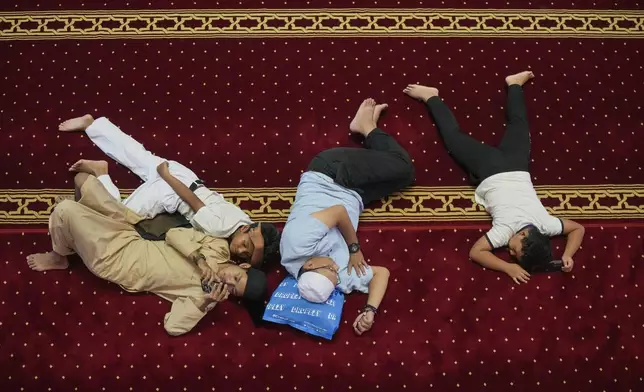 Muslim men rest after the first Friday prayer of the fasting month of Ramadan at Istiqlal Mosque in Jakarta, Indonesia, Friday, March 7, 2025. (AP Photo/Tatan Syuflana)