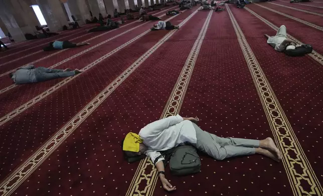 Indonesian Muslim men rest as they wait for the time to break their fast during the first day of the holy fasting month of Ramadan at Istiqlal mosque in Jakarta, Indonesia, Saturday, March 1, 2025. (AP Photo/Achmad Ibrahim)