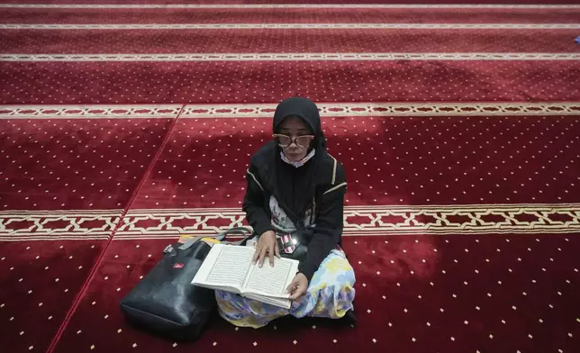 A woman reads the Quran during the holy fasting month of Ramadan at Istiqlal Mosque in Jakarta, Indonesia, Friday, March 7, 2025. (AP Photo/Tatan Syuflana)