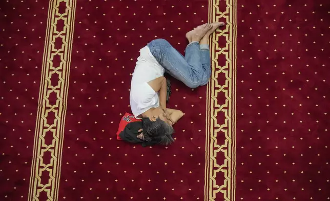 A man rests after the first Friday prayer of the fasting month of Ramadan at Istiqlal Mosque in Jakarta, Indonesia, Friday, March 7, 2025. (AP Photo/Tatan Syuflana)