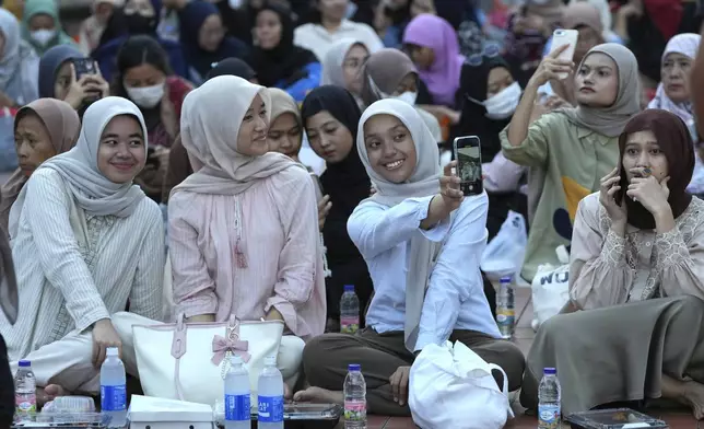 Muslims take a selfie as they wait for the time to break their Ramadan fast at Istiqlal Mosque in Jakarta, Indonesia, Saturday, March 1, 2025. (AP Photo/Achmad Ibrahim)
