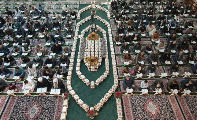 Shiites read the Quran at the holy shrine of Imam Abbas during the holy month of Ramadan in Karbala, Iraq, Wednesday, March 12, 2025. (AP Photo/Hadi Mizban)