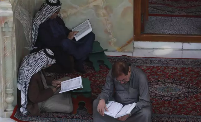Shiites read the Quran at the holy shrine of Imam Abbas during the holy month of Ramadan in Karbala, Iraq, Wednesday, March 12, 2025. (AP Photo/Hadi Mizban)