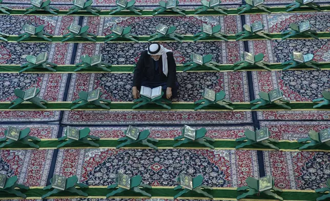 Shiites read the Quran at the holy shrine of Imam Abbas during the holy month of Ramadan in Karbala, Iraq, Wednesday, March 12, 2025. (AP Photo/Hadi Mizban)