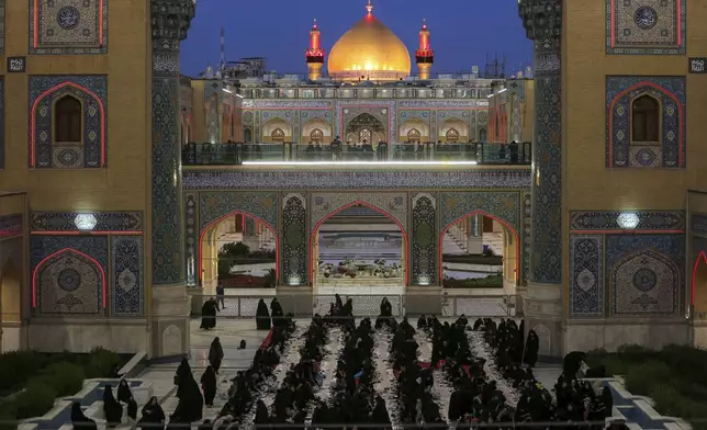 Shiites break their fast during the Islamic holy month of Ramadan in the Imam Ali shrine in Najaf, Iraq, Friday, March 21, 2025. (AP Photo/Anmar Khalil)