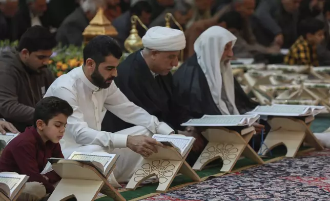 Shiites read the Quran at the holy shrine of Imam Abbas during the holy month of Ramadan in Karbala, Iraq, Wednesday, March 12, 2025. (AP Photo/Hadi Mizban)