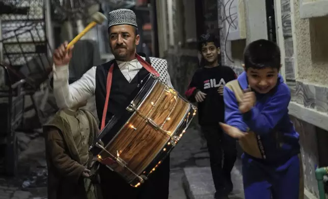Bakr Qusay, a 35-year-old "mesaharati" or dawn caller wakes people up for a meal before sunrise, during the Islamic holy month of Ramadan, in the poor neighborhood of Fadhil district in Baghdad, Iraq, Wednesday, March 12, 2025. (AP Photo/Hadi Mizban)