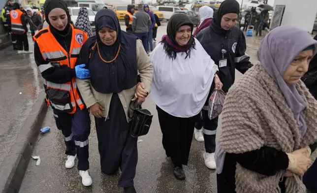 Volunteer paramedics help elderly Palestinian women while they try to crosses from the Israeli military Qalandia checkpoint near the West Bank city of Ramallah to Jerusalem, to participate in the Friday prayers at the Al-Aqsa Mosque compound during the Muslim holy month of Ramadan on Friday, March 21, 2025. (AP Photo/Nasser Nasser)