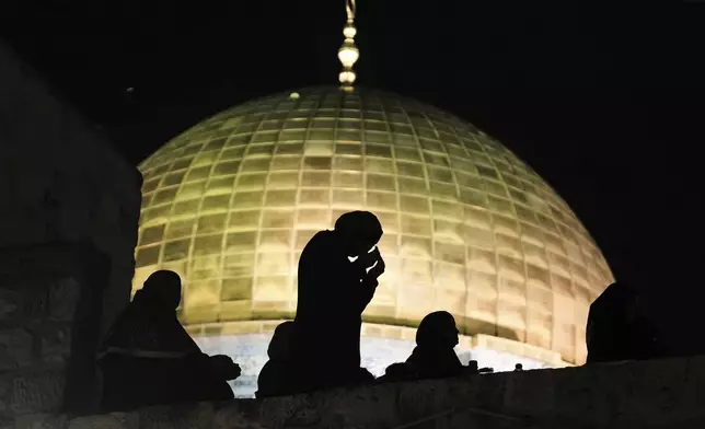 Palestinian Muslim women pray during Laylat Al Qadr, also known as the Night of Power and marked on the 27th day of the holy fasting month of Ramadan, in front of the Dome of the Rock shrine at the Al-Aqsa Mosque compound in the Old City of Jerusalem, Wednesday, March 26, 2025. (AP Photo/Mahmoud Illean)