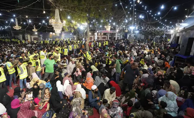 Families eat pre-dawn meal or 'Sehri' to start their fasting during the Muslim's holy fasting month of Ramadan, at a free meal distribution center run by a charity group, in Karachi, Pakistan Sunday, March 2, 2025. (AP Photo/Fareed Khan)