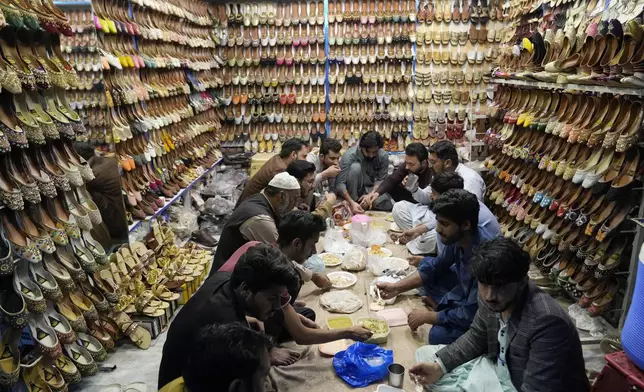 Shopkeepers break their fast during the holy fasting month of Ramadan, at a shop in Lahore, Pakistan, Monday, March 10, 2025. (AP Photo/K.M Chaudary)