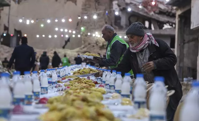 A table is prepared for iftar, the fast-breaking meal, organized by the Turkish Humanitarian Relief Foundation (IHH), on the first day of Ramadan in the Jobar neighborhood, which was devastated by the Syrian war, in Damascus, Syria, on Saturday, March 1, 2025.(AP Photo/Ghaith Alsayed)