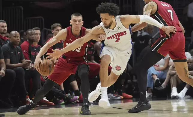 Detroit Pistons guard Cade Cunningham (2) defends Miami Heat guard Tyler Herro (14) during the first half of an NBA basketball game, Wednesday, March 19, 2025, in Miami. (AP Photo/Marta Lavandier)