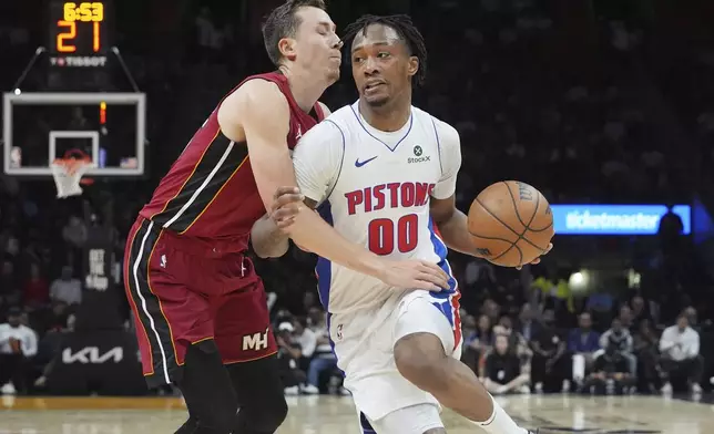 Miami Heat forward Duncan Robinson (55) defends Detroit Pistons forward Ronald Holland II (00) during the first half of an NBA basketball game, Wednesday, March 19, 2025, in Miami. (AP Photo/Marta Lavandier)