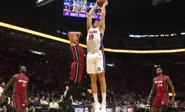 Detroit Pistons forward Simone Fontecchio (19) aims to dunk the ball as Miami Heat guard Tyler Herro (14) defends during the first half of an NBA basketball game, Wednesday, March 19, 2025, in Miami. (AP Photo/Marta Lavandier)