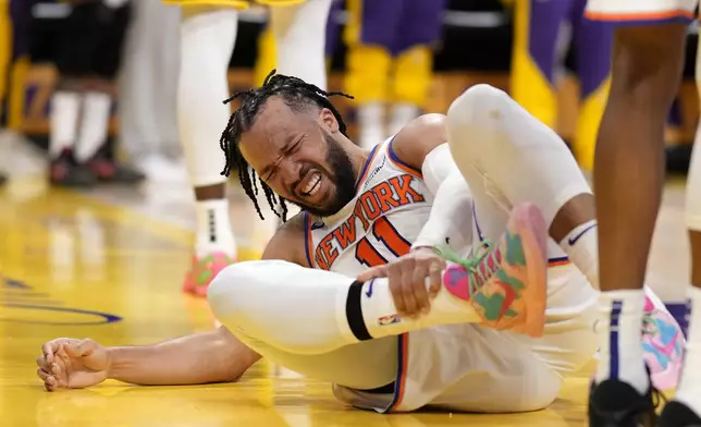 New York Knicks guard Jalen Brunson writhes in pain after getting injured during the second half of an NBA basketball game against the Los Angeles Lakers, Thursday, March 6, 2025, in Los Angeles. (AP Photo/Mark J. Terrill)