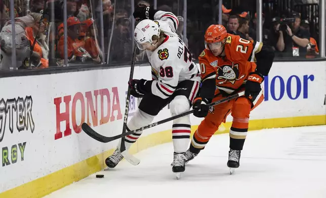 Chicago Blackhawks defenseman Ethan Del Mastro, left, and Anaheim Ducks right wing Brett Leason (20) vie for the puck during the first period of an NHL hockey game Saturday, March 1, 2025, in Anaheim, Calif. (AP Photo/William Liang)