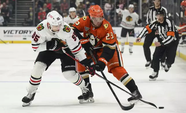 Chicago Blackhawks right wing Ilya Mikheyev (95) and Anaheim Ducks center Mason McTavish (23) vie for the puck during the second period of an NHL hockey game Saturday, March 1, 2025, in Anaheim, Calif. (AP Photo/William Liang)