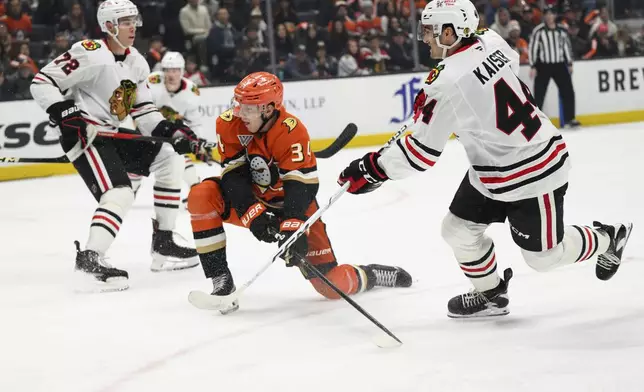 Chicago Blackhawks defenseman Wyatt Kaiser, right, shoots and scores during the second period of an NHL hockey game against the Anaheim Ducks, Saturday, March 1, 2025, in Anaheim, Calif. (AP Photo/William Liang)