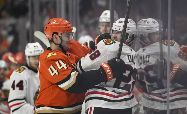 Anaheim Ducks left wing Ross Johnston (44) and Chicago Blackhawks center Colton Dach, right, fight during the first period of an NHL hockey game Saturday, March 1, 2025, in Anaheim, Calif. (AP Photo/William Liang)