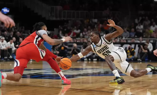 Michigan State forward Coen Carr (55) and Mississippi guard Dre Davis (14) vie for a loose ball during the first half in the Sweet 16 of the NCAA college basketball tournament, Friday, March 28, 2025, in Atlanta. (AP Photo/Brynn Anderson)