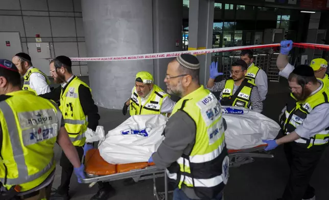 Members of ZAKA rescue services carry the body of a 70-year-old killed in stabbing attack in Haifa, Israel, on Monday, March 30, 2025. Four others were also injured in the incident. (AP Photo/Ariel Schalit)