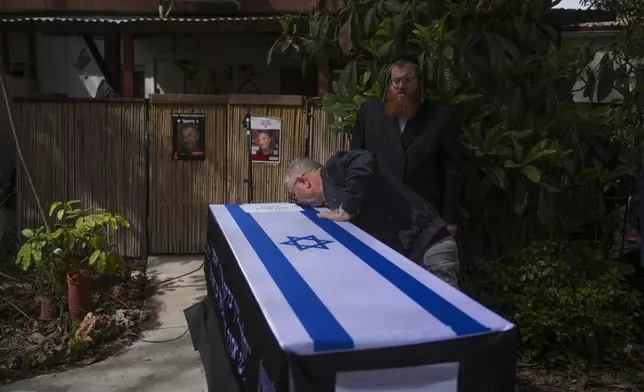 Danny Elgarat, kisses coffin of his brother, Itzhak Elgarat, a slain hostage who was held captive by Hamas in Gaza, during his funeral procession in Kibbutz Nir Oz, Israel, on Monday, March 3, 2025. (AP Photo/Ohad Zwigenberg)