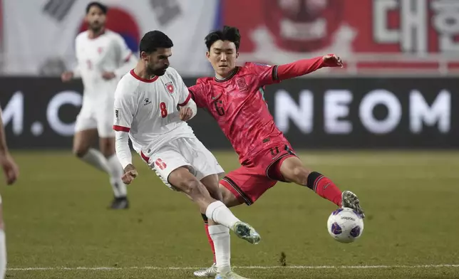 Jordan's Nizar Al Rashdan, left, and South Korea's Hwang In-beom, right, fight for the ball during the third round of the Asian qualifier group B match between South Korea and Jordan for 2026 World Cup at Suwon World Cup Stadium in Suwon, South Korea, Tuesday, March 25, 2025. (AP Photo/Lee Jin-man)