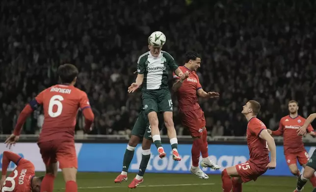 Panathinaikos' Karol Swiderski heads the ball nest to Fiorentina's Rolando Mandragora, right, during the Europa Conference League round of 16 first leg soccer match between Panathinaikos and Fiorentina at the Olympic stadium in Athens, Greece, Thursday, March 6, 2025. (AP Photo/Thanassis Stavrakis)