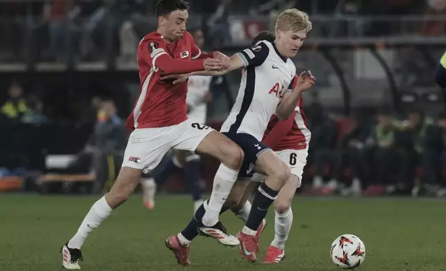 Tottenham's Lucas Bergvall, right, challenges for the ball with AZ Alkmaar's Zico Buurmeester during the Europa League round of 16 first leg match between AZ and Tottenham at AFAS Stadium, in Alkmaar, in Alkmaar, Netherlands, Thursday, March 6, 2025. (AP Photo/Patrick Post)