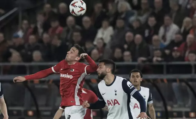 AZ Alkmaar's Jordy Clasie, left, jumps for the ball with Tottenham's Rodrigo Bentancur during the Europa League round of 16 first leg soccer match between AZ Alkmaar and Tottenham Hotspur at the AFAS Stadium, in Alkmaar, Netherlands, Thursday, March 6, 2025. (AP Photo/Patrick Post)
