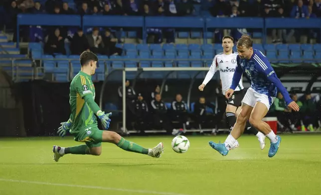 Molde's Fredrik Gulbrandsen, right, scores his side's third goal during the Conference League round of 16 first leg soccer match between Molde FK and Legia Warszawa in Molde, Norway, Thursday, March 6, 2025. (Svein Ove Ekornesvag/NTB Scanpix via AP)