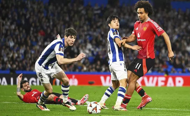 Manchester United's Joshua Zirkzee, right, challenges for the ball with Real Sociedad's Takefusa Kubo during the Europa League round of 16 first leg soccer match between Real Sociedad and Manchester United at the Reale Arena in San Sebastian, Spain, Thursday, March 6, 2025. (AP Photo/Miguel Oses)