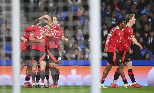 Manchester United players celebrate after Manchester United's Joshua Zirkzee scored his side's opening goal during the Europa League round of 16 first leg soccer match between Real Sociedad and Manchester United at the Reale Arena in San Sebastian, Spain, Thursday, March 6, 2025. (AP Photo/Miguel Oses)