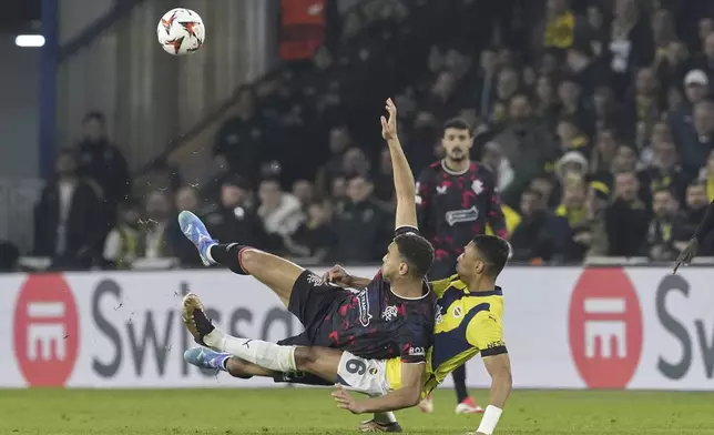 Rangers' Cyriel Dessers, left, fights for the ball with Fenerbahce's Alexander Djiku during the Europa League round of 16 first leg soccer match between Fenerbahce and Rangers at Sukru Saracoglu stadium in Istanbul, Turkey, Thursday, March 6, 2025. (AP Photo/Khalil Hamra)