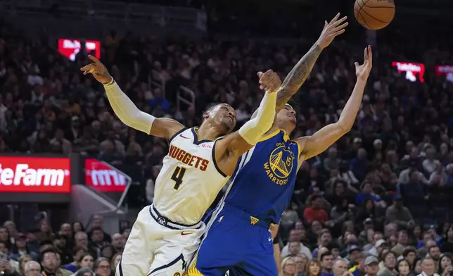 Denver Nuggets guard Russell Westbrook, left, and Golden State Warriors forward Gui Santos compete for a rebound during the first half of an NBA basketball game Monday, March 17, 2025, in San Francisco. (AP Photo/Godofredo A. Vásquez)