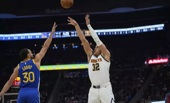 Denver Nuggets forward Aaron Gordon, right shoots a 3-point basket over Golden State Warriors guard Stephen Curry during the first half of an NBA basketball game Monday, March 17, 2025, in San Francisco. (AP Photo/Godofredo A. Vásquez)