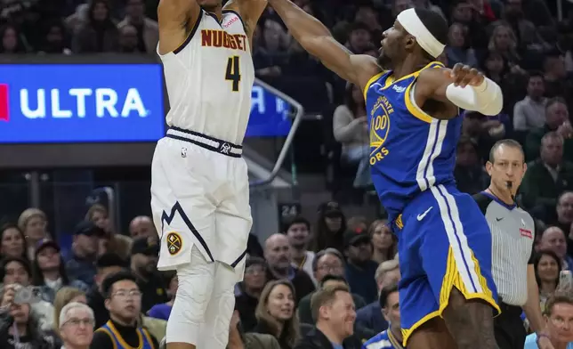 Denver Nuggets guard Russell Westbrook, left, shoots a 3-point basket over Golden State Warriors forward Jonathan Kuminga during the first half of an NBA basketball game Monday, March 17, 2025, in San Francisco. (AP Photo/Godofredo A. Vásquez)
