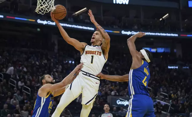 Denver Nuggets forward Michael Porter Jr. (1) shoots between Golden State Warriors guards Stephen Curry, left, and Moses Moody during the first half of an NBA basketball game Monday, March 17, 2025, in San Francisco. (AP Photo/Godofredo A. Vásquez)